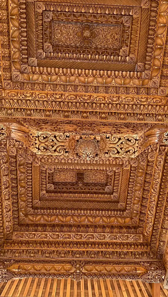 Detail ukiran kayu bertingkat di plafon joglo